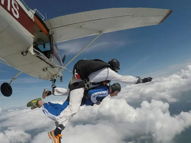 Two people skydiving from a private plane.